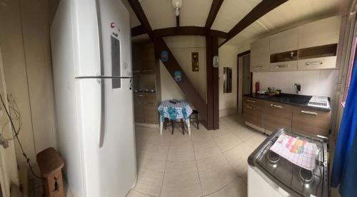 a kitchen with a table and a refrigerator at Pousada Voo Livre - Ilha do Mel in Ilha do Mel