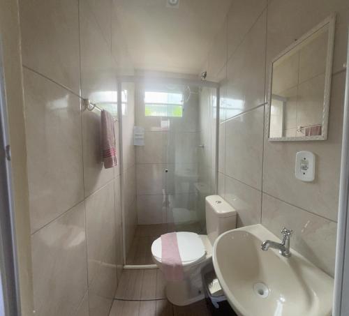 a bathroom with a shower and a toilet and a sink at Pousada Voo Livre - Ilha do Mel in Ilha do Mel
