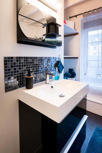 une salle de bain avec un lavabo blanc et un miroir dans l'établissement Maison Léonard, à Honfleur