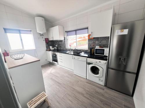 a kitchen with a stainless steel refrigerator and a dishwasher at Casa Dom Simões in Aljezur