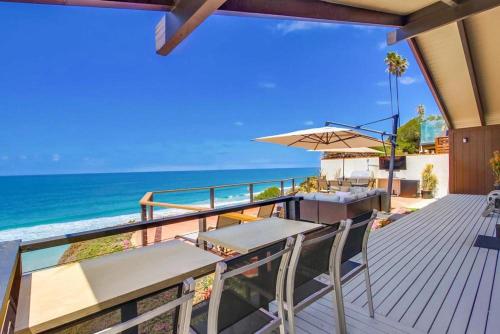 a deck with a table and chairs and the ocean at Socal Style in Encinitas