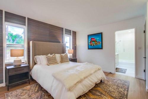 a bedroom with a large bed and two windows at Socal Style in Encinitas