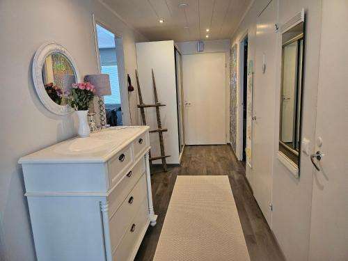 uma casa de banho com uma cómoda branca e um espelho em Viihtyisä rivitalokolmio autopaikalla em Kangasala