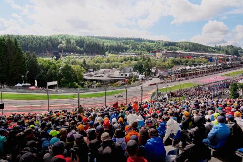 una multitud de personas viendo una carrera en una pista en GrandPrixCamp closest to the track including track view, en Stavelot