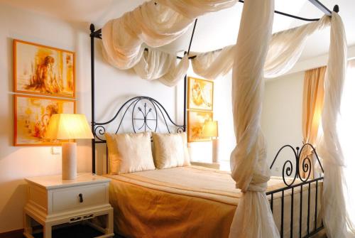 a bedroom with a canopy bed with a window at Hotel Moliceiro in Aveiro