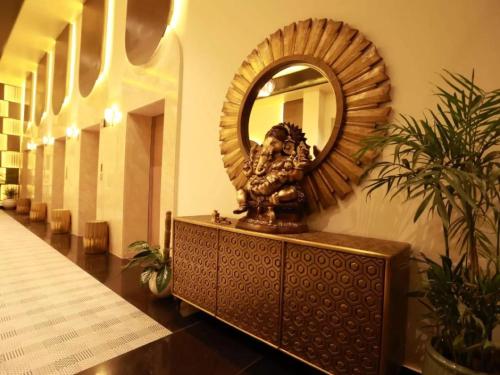 un espejo en una pared con una estatua en un pasillo en Diona Anukampa Suite with pool, en Jaipur