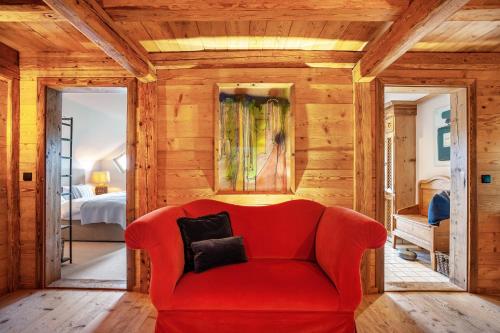 a red couch in a room with a bedroom at Windhäusern5 in Wangen im Allgäu