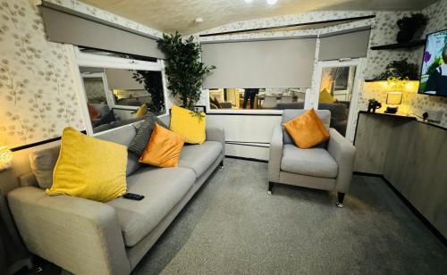 斯凱格內斯的住宿－Golden Sands，客厅配有沙发和两把椅子