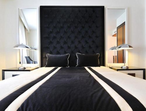a bedroom with a large bed with a black headboard at Hotel Moliceiro in Aveiro
