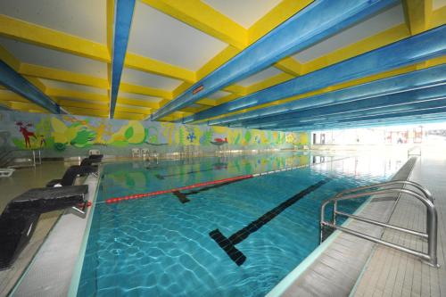 a large swimming pool in a large building at Appartamento Bilocale Residence Albaré - 6 Posti letto in Marilleva