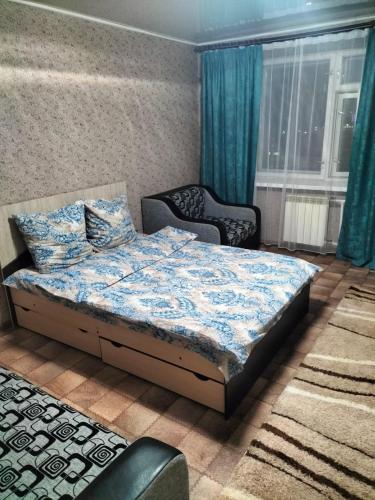 阿斯克卡明諾戈斯克的住宿－APARTMENT at REPUBLIC SQUARE，一间卧室配有一张床和两把椅子