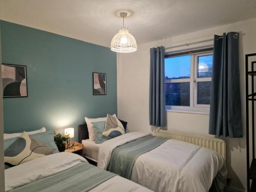 two beds in a room with a window at Charming Home in Stourport Sleeps10 with Wifi&Parking by PureStay Short Lets in Stourport