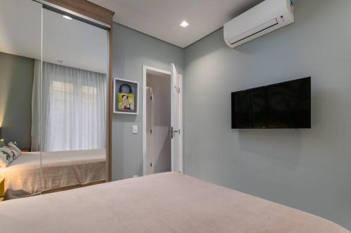 a bedroom with a bed and a flat screen tv at Ipagarden in Rio de Janeiro