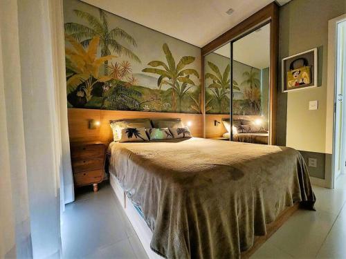 a bedroom with a large bed with a painting on the wall at Ipagarden in Rio de Janeiro