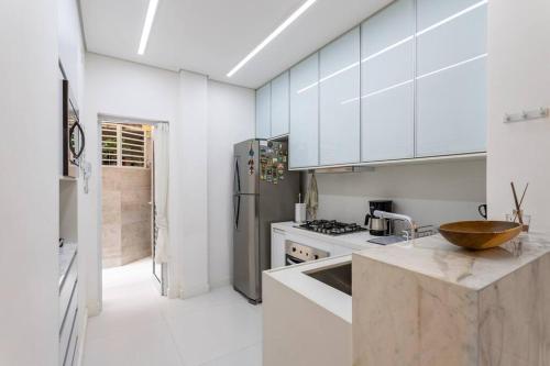 a kitchen with white cabinets and a wooden bowl on the counter at Ipagarden in Rio de Janeiro