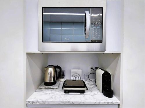 a kitchen with a microwave and a toaster oven at Ipagarden in Rio de Janeiro