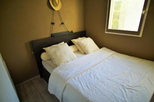 een slaapkamer met een bed met witte lakens en kussens bij Bel appartement moderne, tout à pied in Saint-Mandrier-sur-Mer