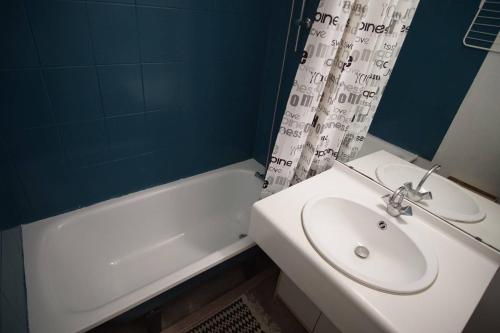 een badkamer met een wastafel en een bad met een douchegordijn bij Bel appartement moderne, tout à pied in Saint-Mandrier-sur-Mer