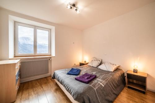 Un dormitorio con una cama con una manta morada. en Appartement proche station - 7 pers, en Châtillon-sur-Cluses