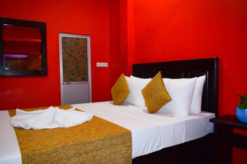 a bedroom with two beds with red walls at Hema Holiday Villa in Trincomalee