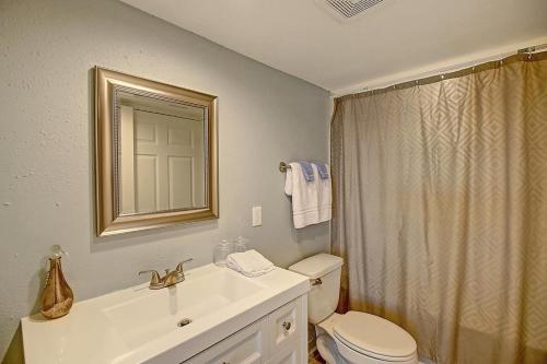 a bathroom with a toilet and a sink and a mirror at A Salty Day Getaway at Sea Sands Condominiums in Port Aransas