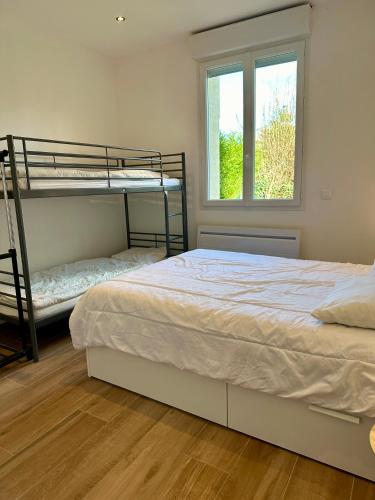 une chambre avec deux lits superposés et une fenêtre dans l'établissement Les 20 collines 4 à 6 pers, à Dieppe