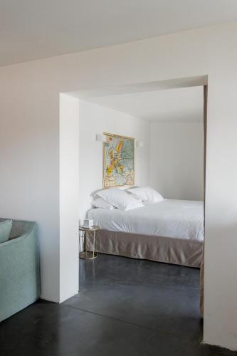 a bedroom with a bed and a painting on the wall at Mas de la Fouque - Hôtel & Spa in Saintes-Maries-de-la-Mer