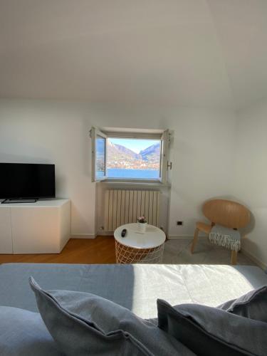 ein Wohnzimmer mit einem Bett und einem Fenster in der Unterkunft Casa di Gio in Malgrate