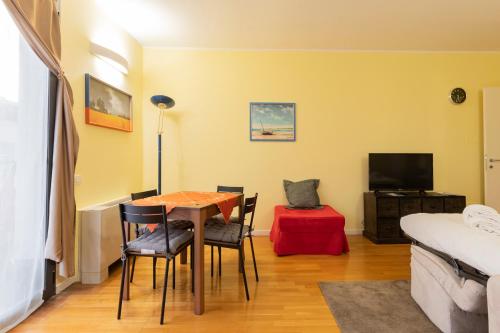 Una sala de estar con una mesa y sillas y una cama. en Xenia Apartments - Elegant studio 10 min from Linate, en Milán