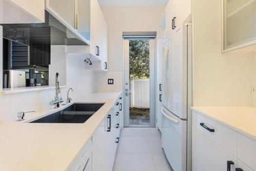 a kitchen with white counters and a sink at VILLA ST-BARTH Waterfront w htd pool by VIAC in Fort Lauderdale