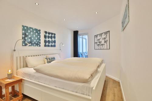- une chambre blanche avec un grand lit blanc dans l'établissement Residenz Ostseestrand Appartement 14, à Scharbeutz