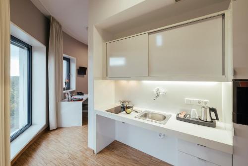 a white kitchen with a sink and a window at GZT Das Gästehaus in Tübingen