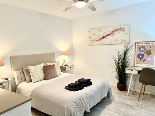 een slaapkamer met een bed met witte lakens en een bureau bij El patio de Tendillas in Córdoba