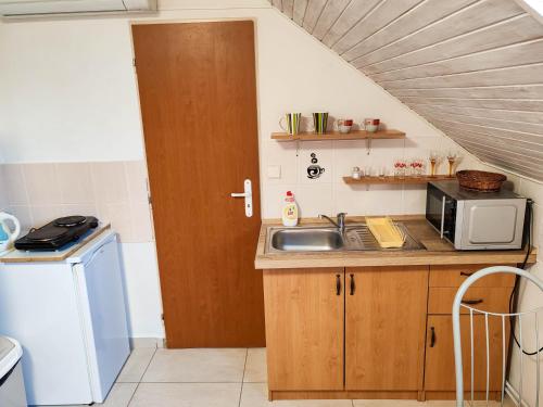 a kitchen with a sink and a microwave at Ubytovanie LISKA in Radava