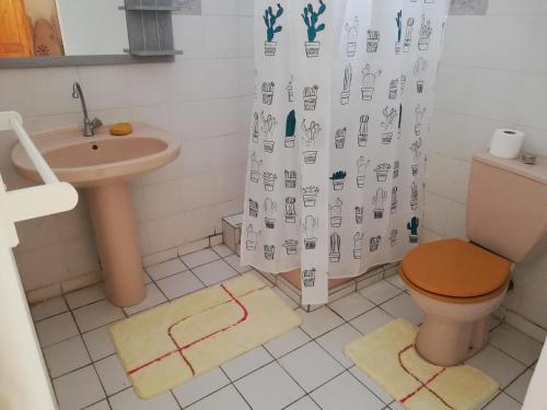 La salle de bains est pourvue de toilettes, d'un lavabo et d'un rideau de douche. dans l'établissement Au paradis créole, à Le Moule