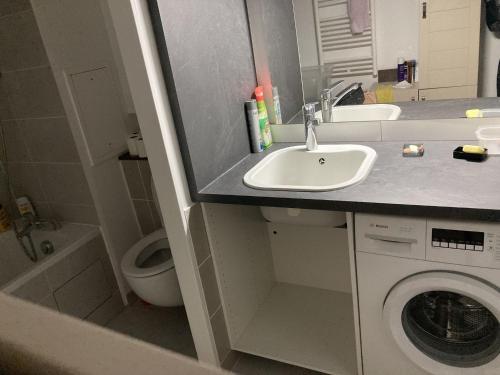 une salle de bain avec un lavabo et une machine à laver dans l'établissement pleyel, à Saint-Denis