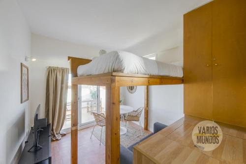 uma cama alta numa sala de estar com uma mesa de jantar em Fabuloso Atico Doble Altura para 3pax en Chueca em Madrid
