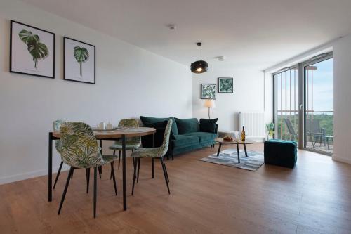 a living room with a green couch and a table and chairs at Apartament Premium Sea View PINEA 704 in Pobierowo