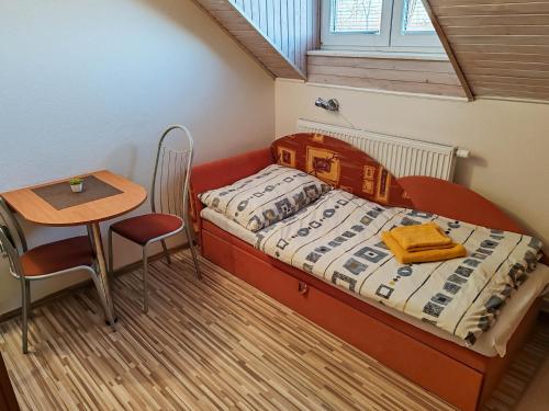 a small bedroom with a bed and a table at Ubytovanie LISKA in Radava
