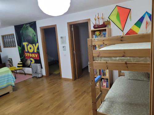 a bedroom with a bunk bed and a room with a book shelf at Coloured Studio in Faro