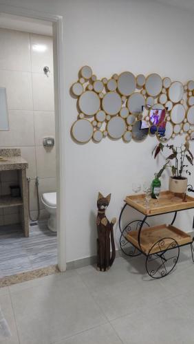 a bathroom with a toilet and a table with a cat at Apart-hotel St° Antônio de Pádua in Santo Antônio de Pádua