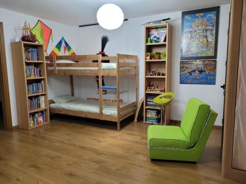 a room with a bunk bed and a green chair at Coloured Studio in Faro