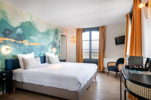 a hotel room with a large bed and a window at H&ocirc;tel de la Cit&eacute; in Saint Malo