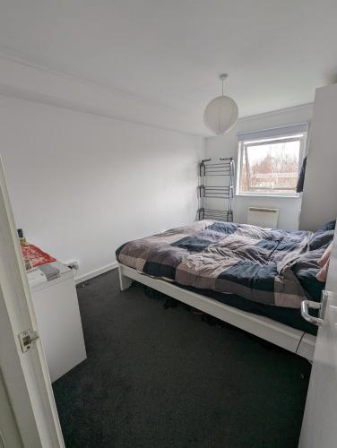 um quarto com uma cama e uma janela em Ali's Flat em Londres