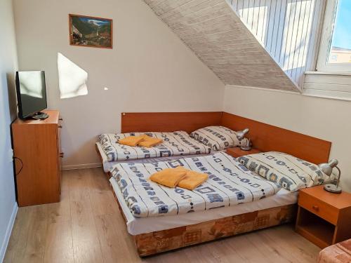 two twin beds in a room with a tv at Ubytovanie LISKA in Radava