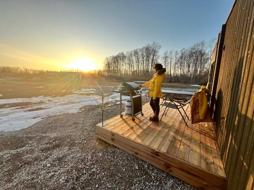 a woman standing on a deck next to a grill at Mesipesa Green Lodge in Laagna