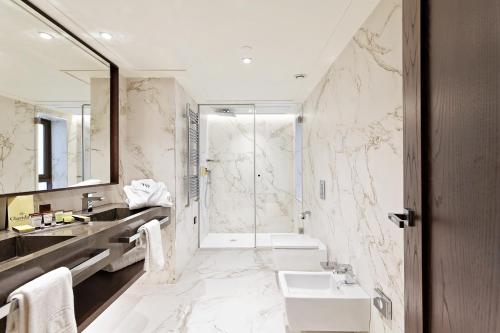 a bathroom with a tub and a sink and a shower at Claridge Madrid in Madrid