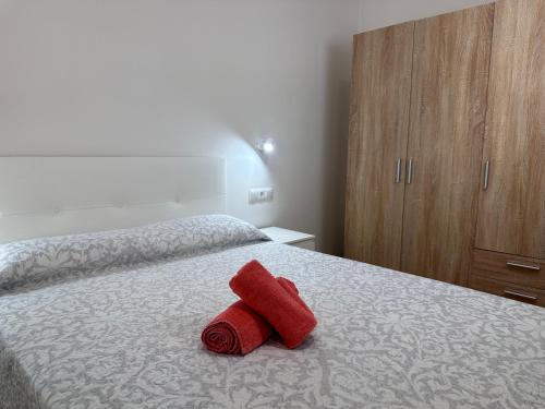 a red towel sitting on top of a bed at Brisa del Mar - 2 min playa in El Ejido