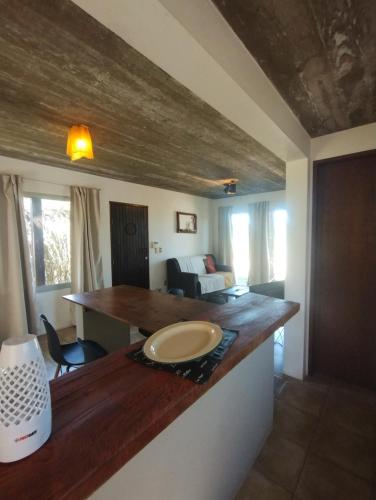 uma cozinha com um balcão de madeira num quarto em Iona em Punta Del Diablo