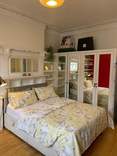 Schlafzimmer mit einem großen Bett und weißen Schränken in der Unterkunft 15 min to The Heart of London - Charming 2 bed Apartment in London